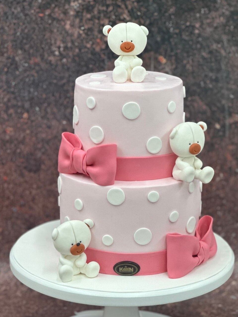 Dvospratna roze torta sa belim tufnama, medvedićima i pink mašnama
