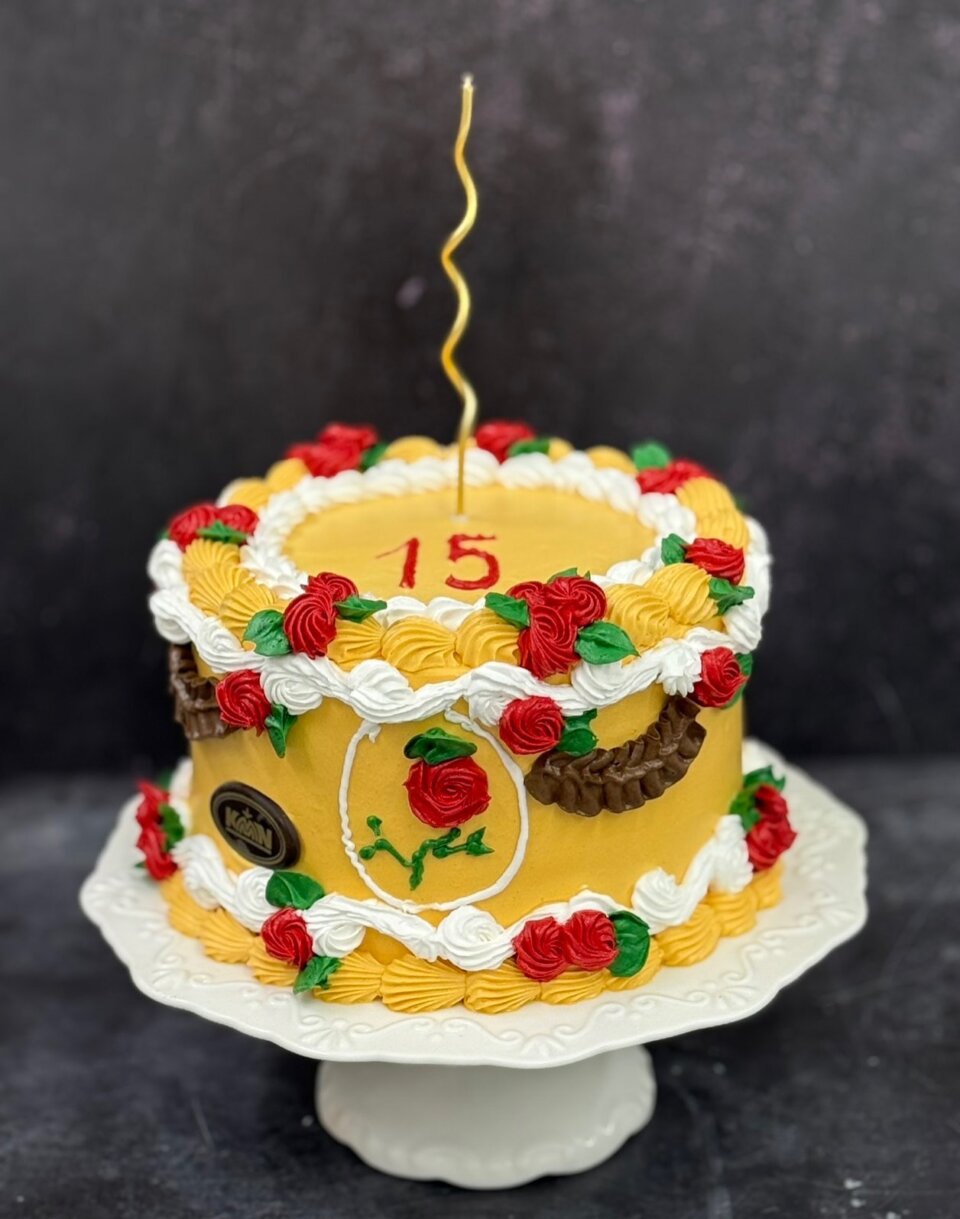 Žuta torta u vintage stilu sa crvenim ružama i belim šlagom