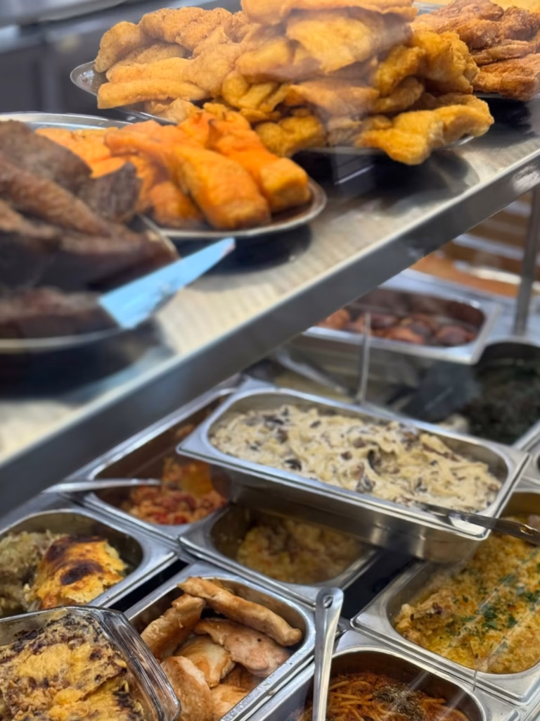 Pohovana jela i variva na pultu ekspres restorana, iza stakla