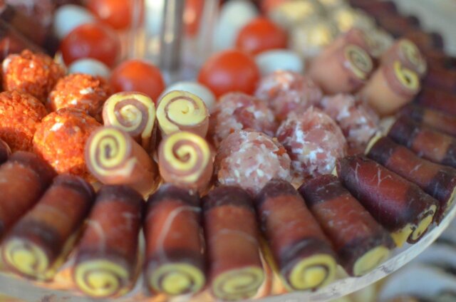 Plato sa rolovanim suvim mesom, sirom i maslinama