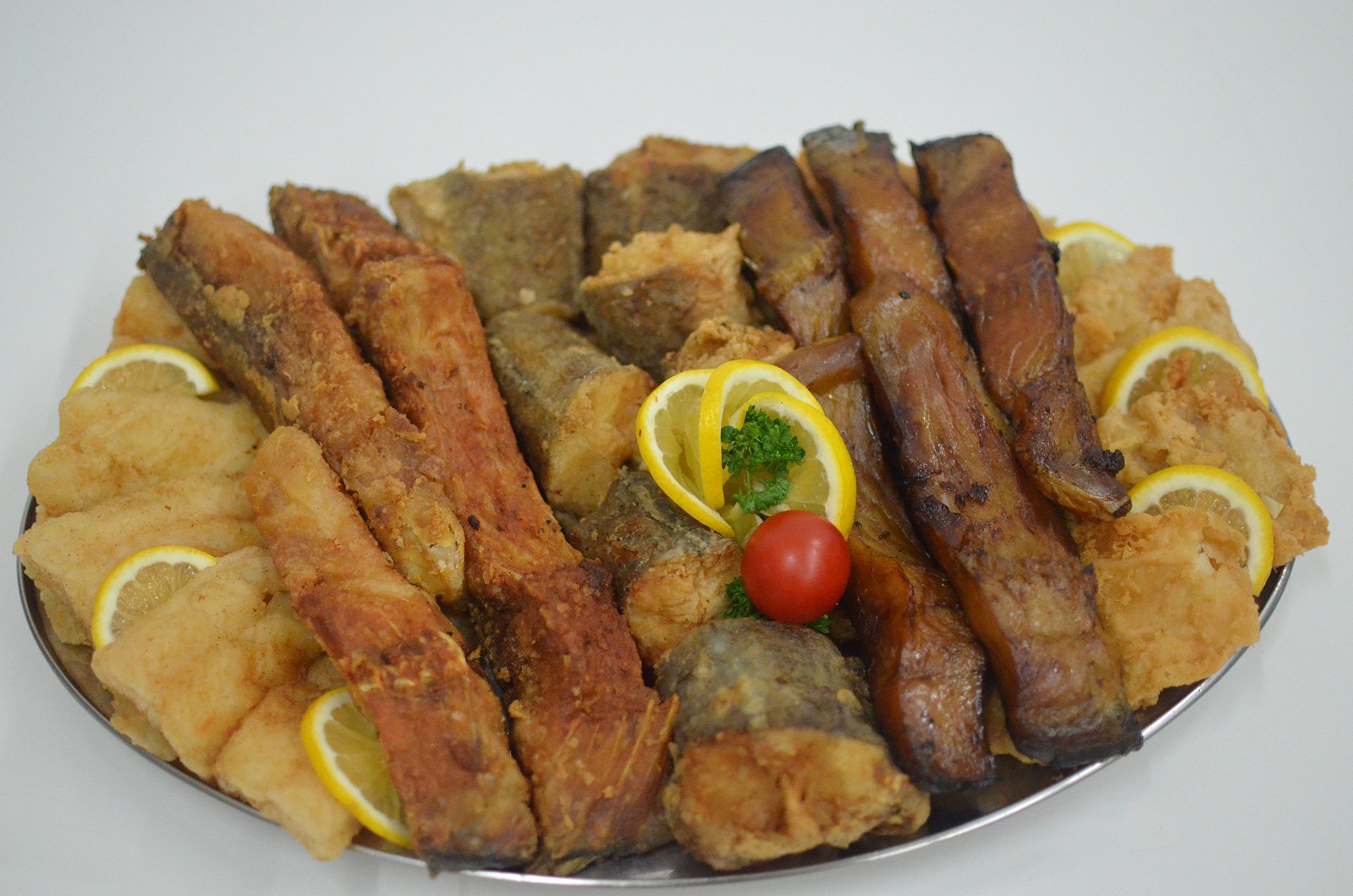 Plato sa prženom i dimljenom ribom i kriškama limuna