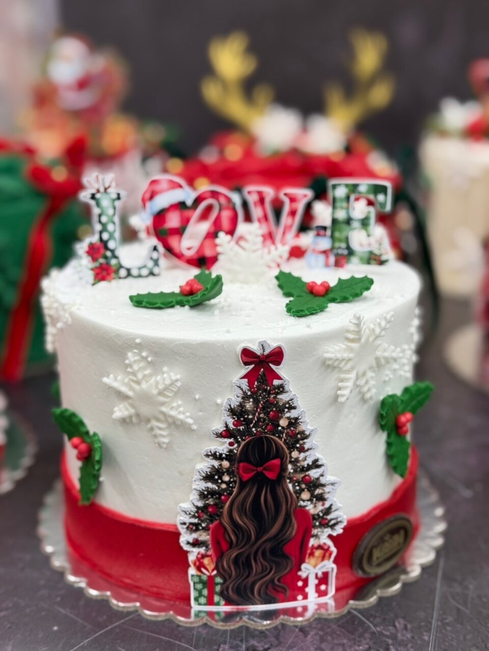 Bela božićna torta sa jelkom, pahuljicama i crvenim detaljima