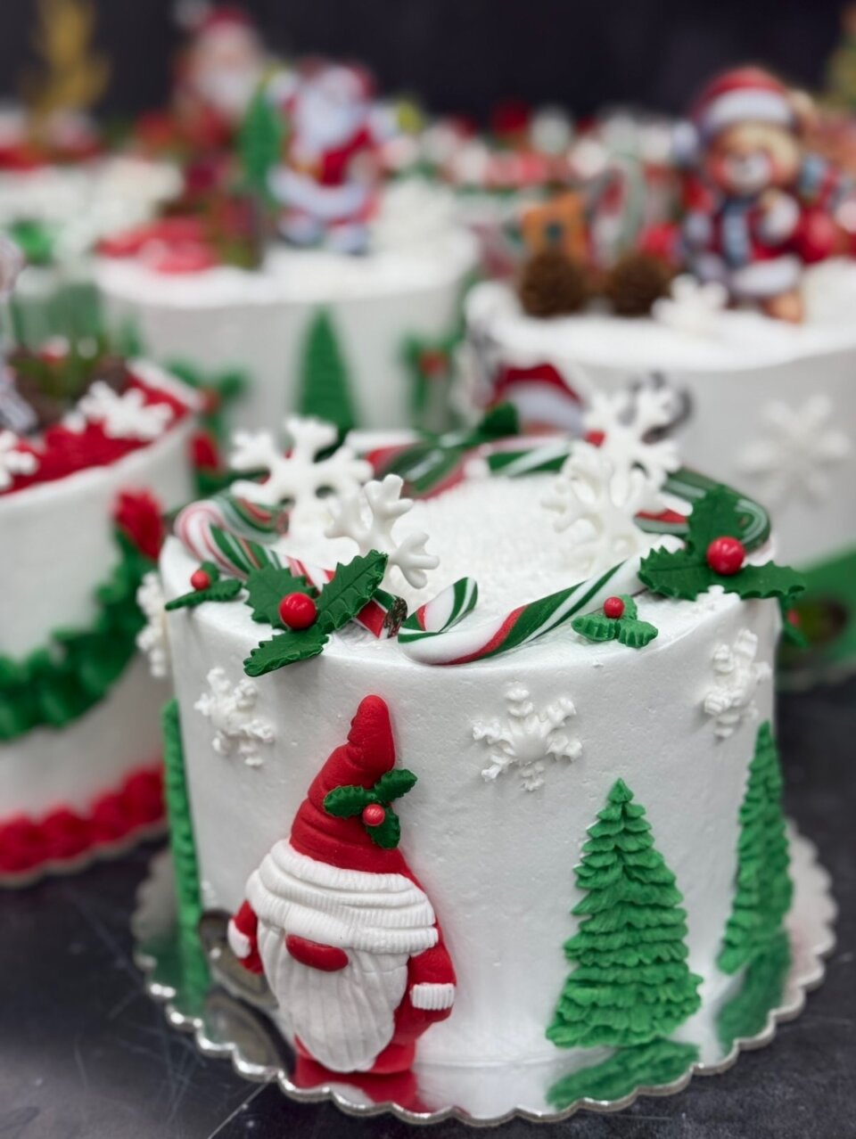 Bela božićna torta sa patuljkom, jelkama i pahuljicama