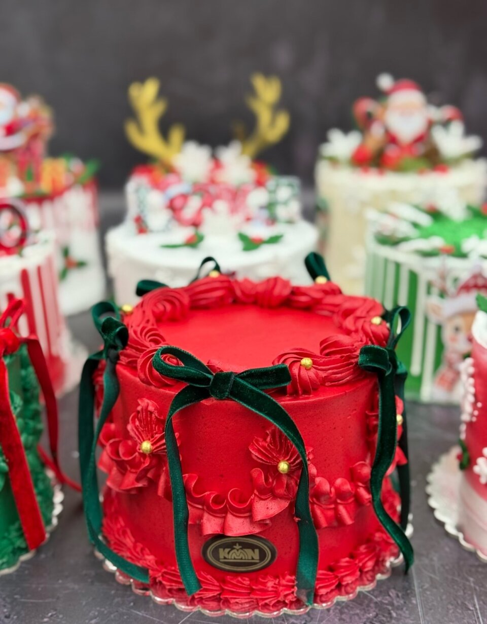 Crvena praznična torta sa šlagom, mašnama i zlatnim perlama
