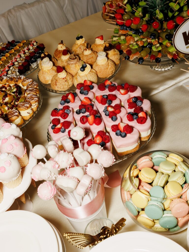 Slatki sto sa roze tortom, cake pops i pastelnim makaronsima